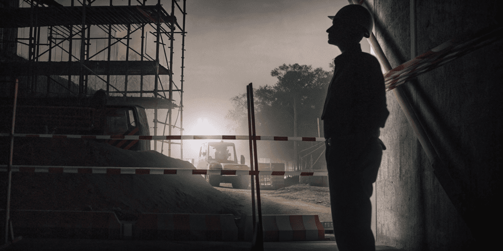 Temporary security fencing protecting a construction site at night.