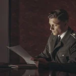 A professional security guard in uniform reviewing a security service agreement contract on a modern desk with warm lighting.