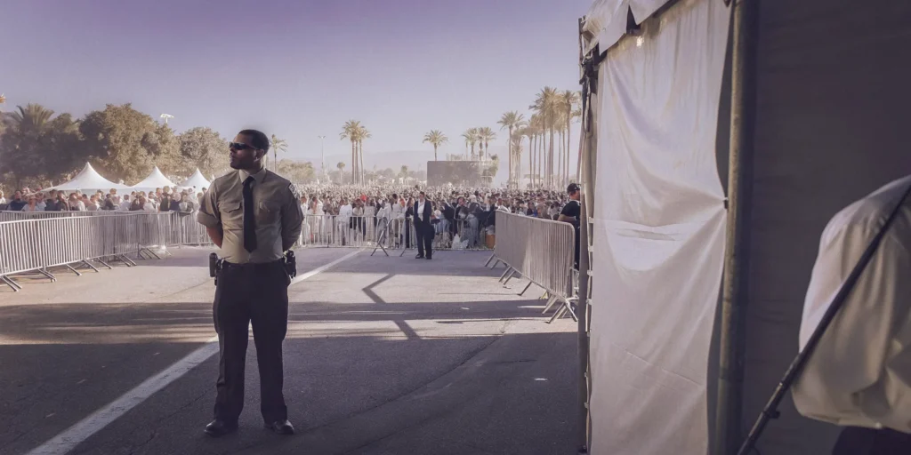 Professional security guard monitoring an outdoor event entrance in Southern California