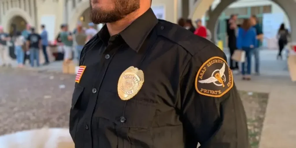 Security officer observing vehicle rows at a car rental facility entrance