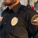 Security officer observing vehicle rows at a car rental facility entrance