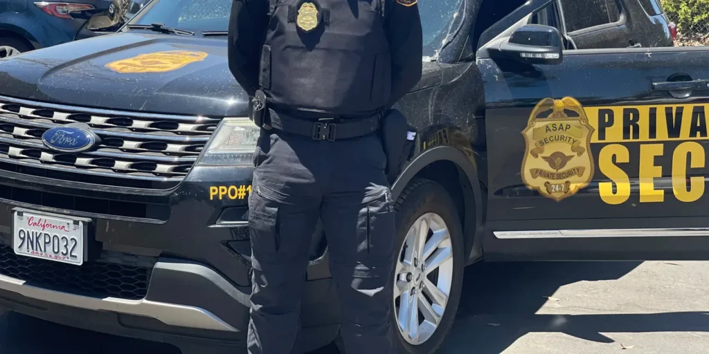 A uniformed security professional reviewing a commercial property entrance in Southern California